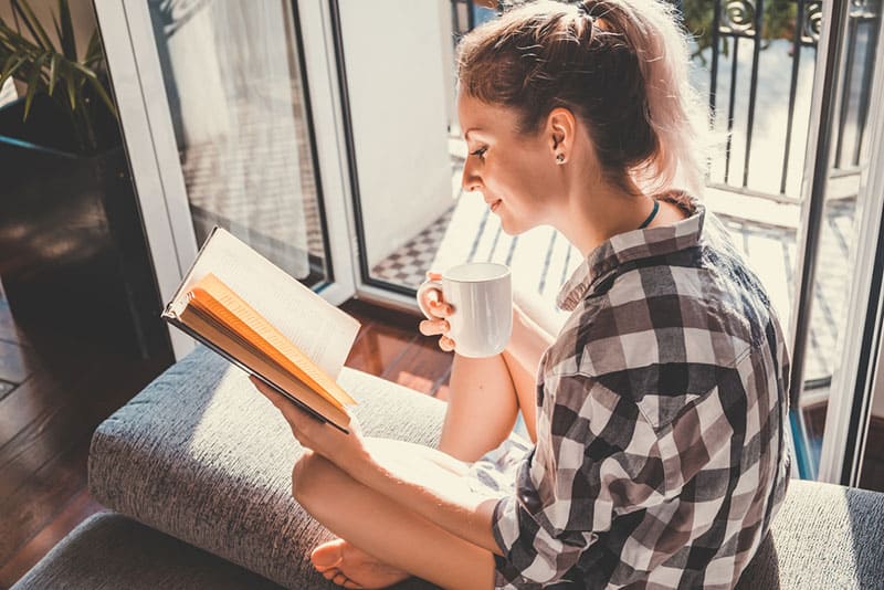 jeune femme, lecture livre, et, café buvant