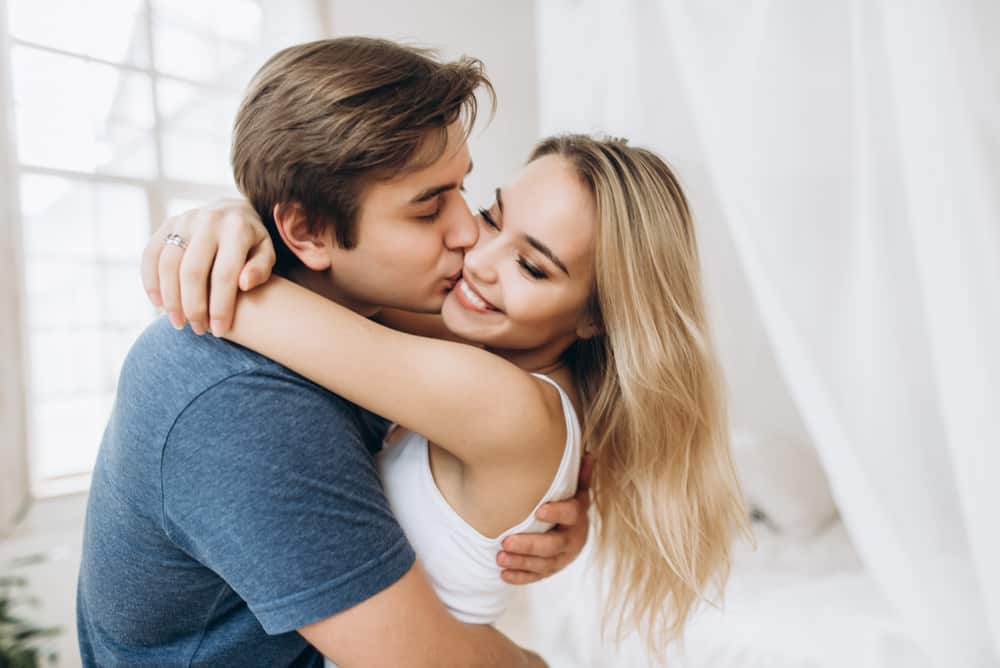 un homme embrasse une femme souriante