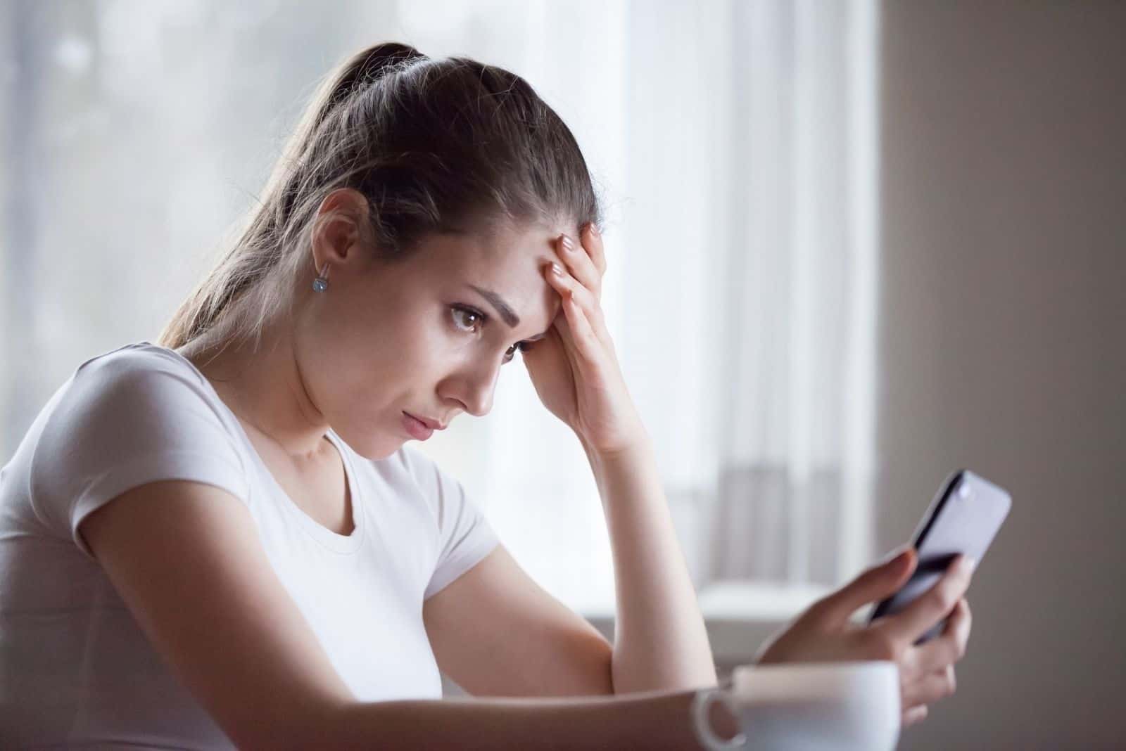 femme déçue par la lecture de mauvaises nouvelles au téléphone, une fille bouleversée reçoit une réponse négative ou de rejet sur mobile