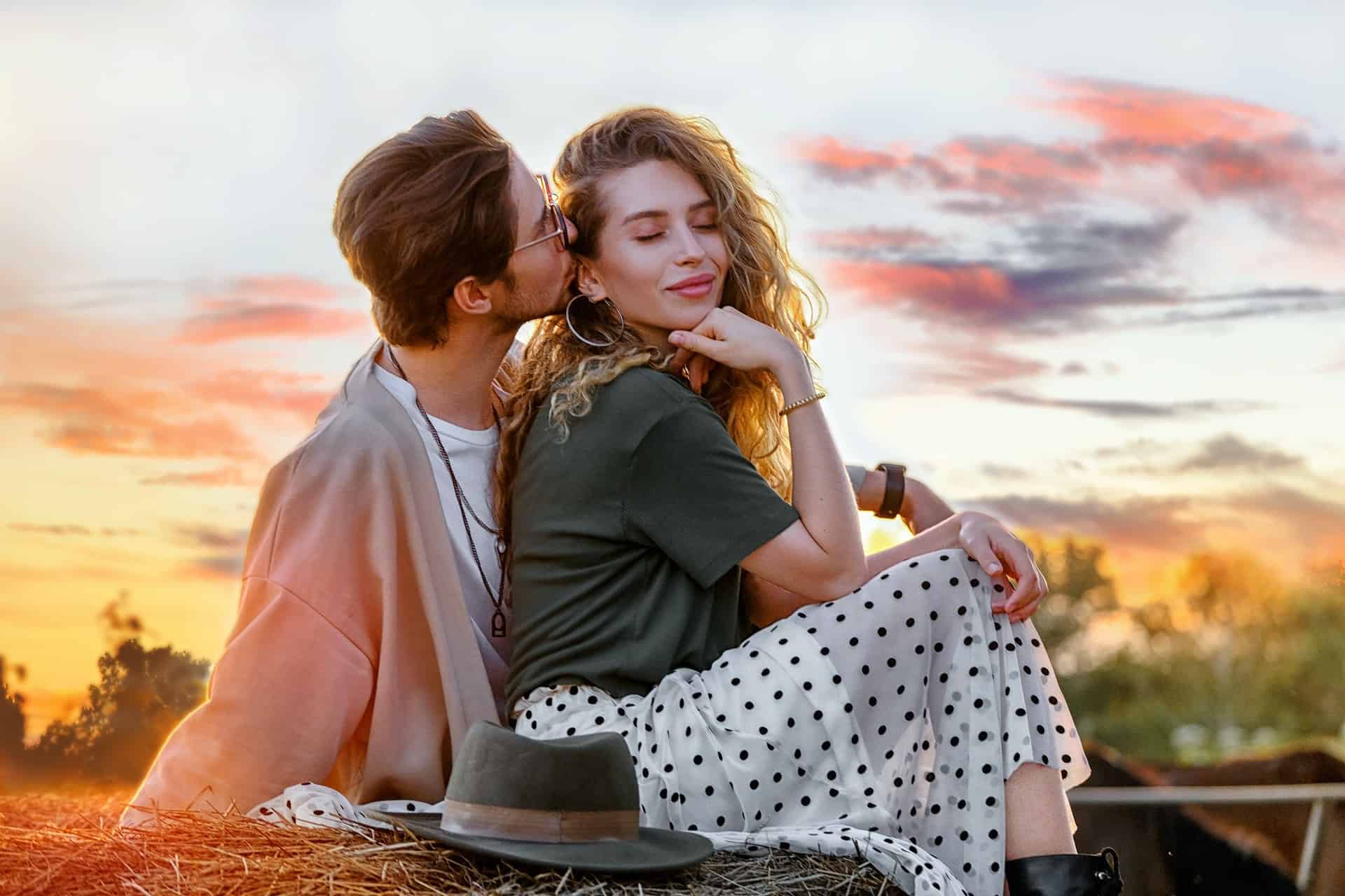 homme embrassant une femme assise sur le sol