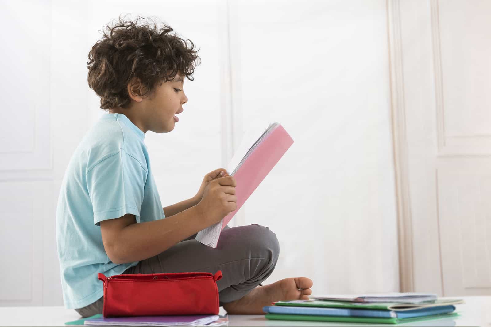 l'enfant est assis par terre et lit