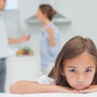 triste petite fille écoutant les parents se battre