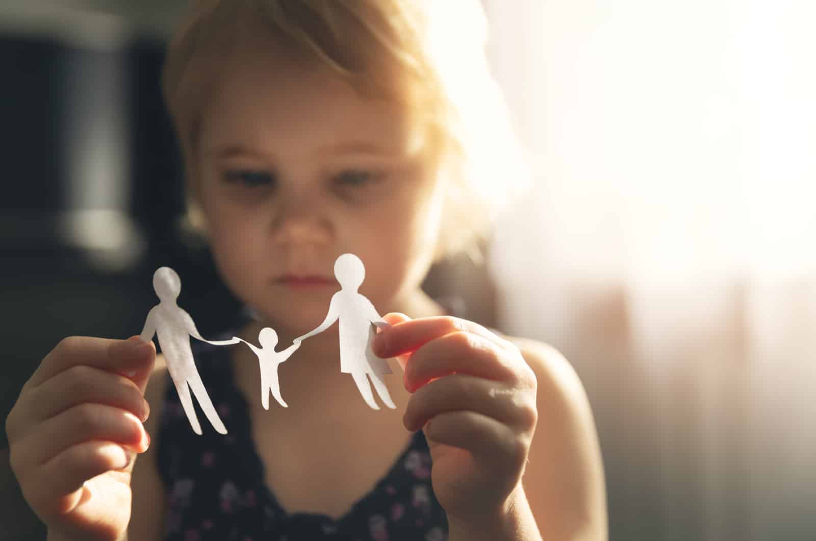 petit enfant tenant une découpe de papier d'une famille